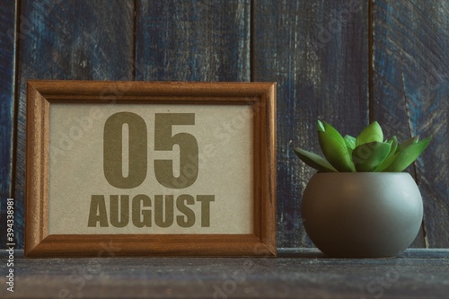 august 5th. Day 5 of month, date in frame next to succulent on wooden background summer month, day of the year concept photo