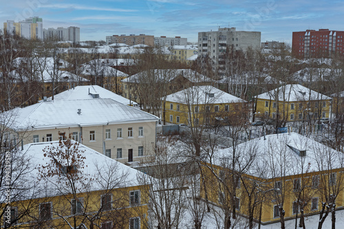 Winter view of a residential neighborhood against a blue sky with white clouds