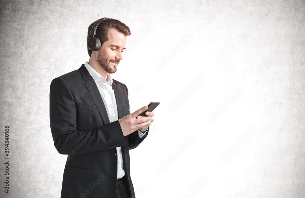 Smiling businessman using smartphone and headphones, mock up Smiling businessman using smartphone and headphones, mock up