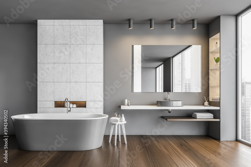 Bathroom in grey and wooden design with row of bathtub  sink and mirror