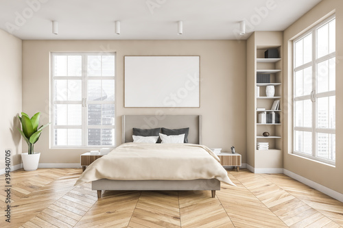 Wooden bedroom and canvas over bed with linens, beige walls and window © ImageFlow