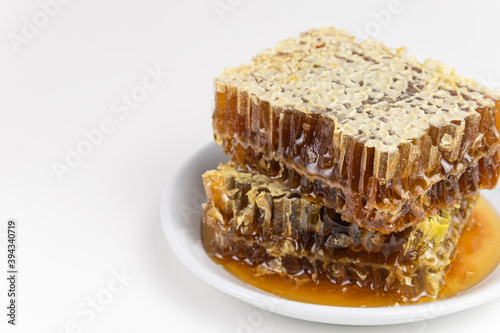 honey and honeycomb on a plate. on a white background