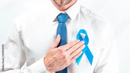 November. Hipster men in bright shirt, cyan tie with blue ribbon in hands on white background. Awareness prostate cancer of men health. Supporting people living and illness.