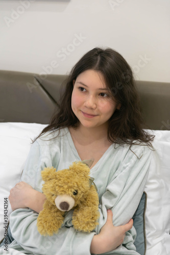 Teenage girl in pyjamas with a Teddy bear on Sunday morning