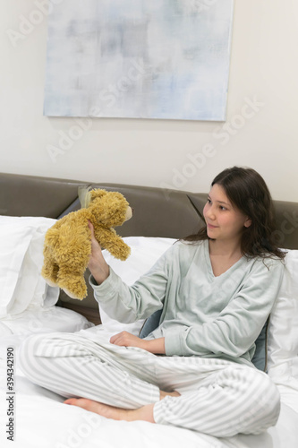 Girl with a Teddy bear, with a favorite toy on Sunday morning in bed very happy