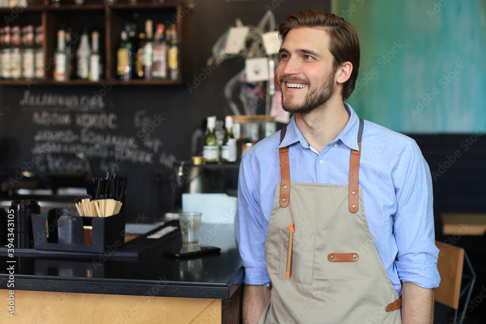 Shot of happy young bar owner standing near the counter, smiling. Shot of happy young bar owner standing near the counter, smiling.