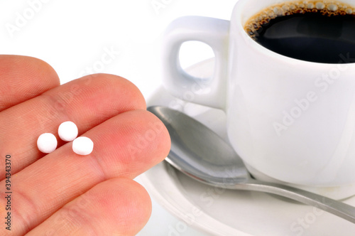 Photos Aspartame dans la main avec une tasse de café au second plan