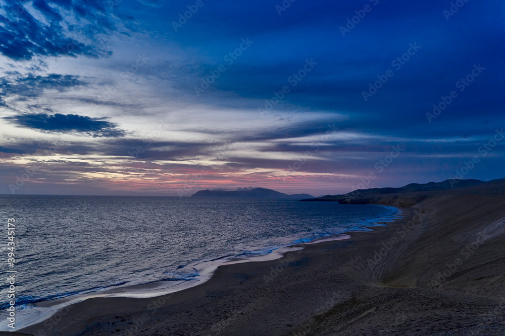 sunset at the coast line of Peru during blue hour at Paracas national park. dramatic eveneing sky