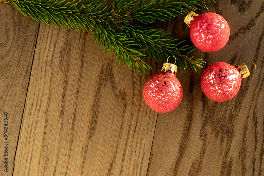 Christmas decoration, a branch of fir tree with three pink baubles on rustic wooden background. Holiday time theme for Christmas and New Year Christmas decoration, a branch of fir tree with three pink baubles on rustic wooden background. Holiday time theme for Christmas and New Year