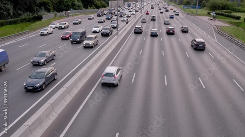 View of busy high way with cars and trcks moving slowly on it.