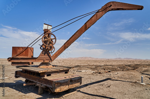 Photos old crane on rails on an abandoned saltpeter mining town in the Atacama desert o