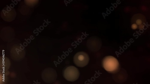 Elegant copy space as looped golden bokeh particles on dark background. Orange gold abstract luxury backplate as shining defocused dust bokeh glitter template with discreet glittering subtle overlay. photo