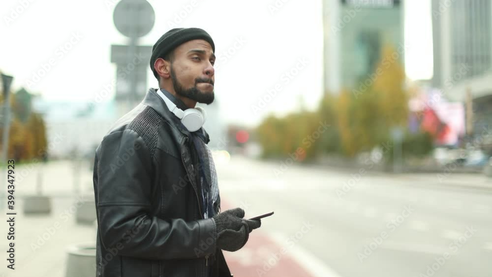 Man in Warsaw using phone and waiting for a taxi 
