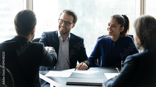 Wide banner view of smiling businesspeople handshake closing deal making agreement at meeting. Happy business partners shake hands get acquainted greeting at briefing. Teamwork, partnership concept.