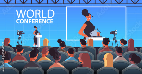 businesswoman giving speech at tribune with microphone on corporate international world conference lecture hall interior horizontal vector illustration