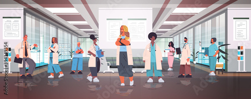 team of mix race doctors in uniform standing together in hospital corridor medicine healthcare concept horizontal full length vector illustration