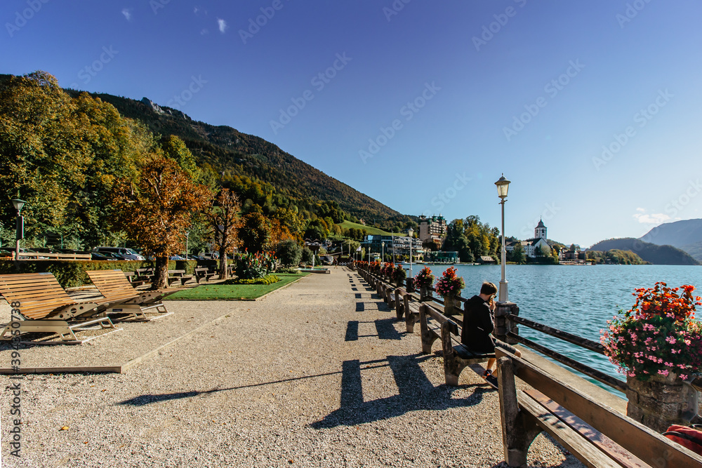 Embankment of St. Wolfgang,Austria. View of small market town on the banks of the lake Wolfgangsee,Salzkammergut region.Austrian cultural tourist attraction.Idyllic sunny day by lake.Travel Europe.