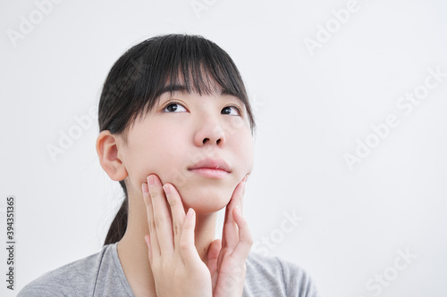 顎をマッサージする日本人女子中学生