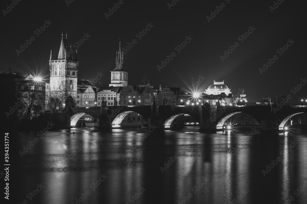 Evening panorama of Prague, Czech Republic. Black and white photo. Charles Bridge,Karluv most reflected in Vltava River. Long exposure city lights.Amazing European cityscape.Travel urban concept.