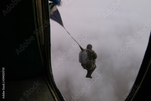Tela A paratrooper has just jumped out of a plane into the cloudy sky.