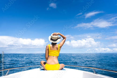 Young adult traveling woman sit on the sailing boat with summe blue sky and sea