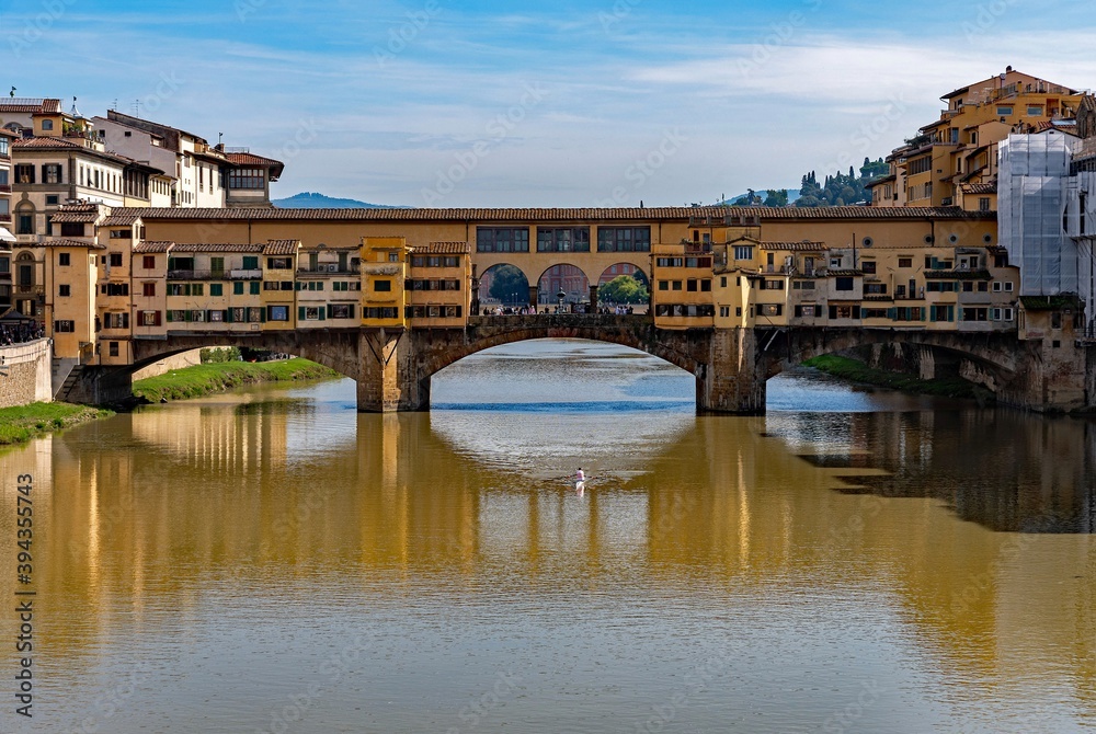 The Ponte Vecchio at Florence reflecting at the Arno River, Tuscany Region in Italy 
