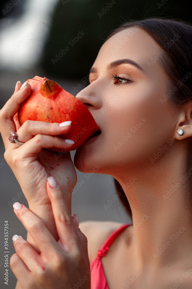 portrait of a young beautiful girl with a pomegranate in her hands.in a red dress. shallow DOF. selective focus. portrait of a young beautiful girl with a pomegranate in her hands.in a red dress. shallow DOF. selective focus.