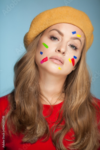 Portrait of a woman with colorful paint brushstroken on face.