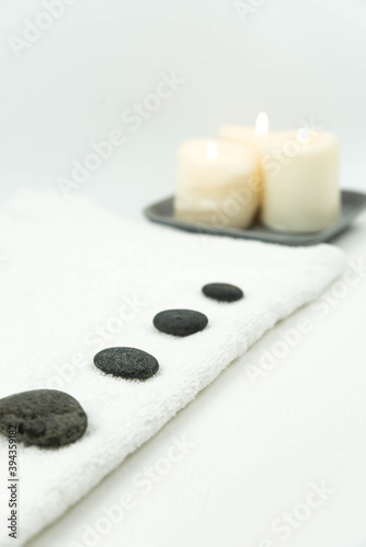 Canvas Print Gray zen pebble hot stones with towel on massage table in beauty salon