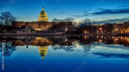 The United States Capitol building at sunset with reflection in water.