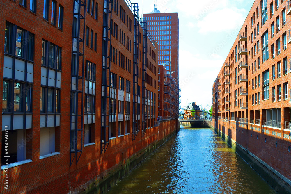 Famous Speicherstadt warehouse district - view of city canal with bridge and red brick buildings. Hamburg, Germany.