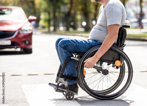 Handicapped man in wheelchair crossing street road © romaset