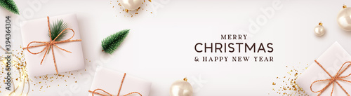 Christmas poster, holiday banner. Merry Christmas and Happy New Year. Xmas Background design lights garland, realistic gifts box, white balls and glitter gold confetti. Lush green tree and pine.