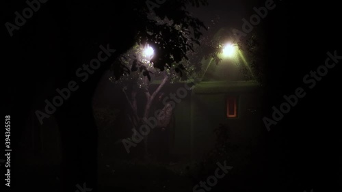 Fairy house and strange man.
A man with long hair comes out of a small green house. He walks from the house and approaches the camera.
