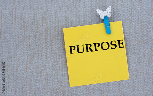 PURPOSE - words on yellow paper with clothespin on gray background