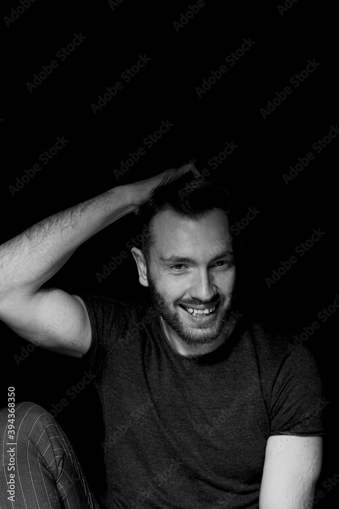 A man on a black background, satisfied with himself and life.Emotion of joy
