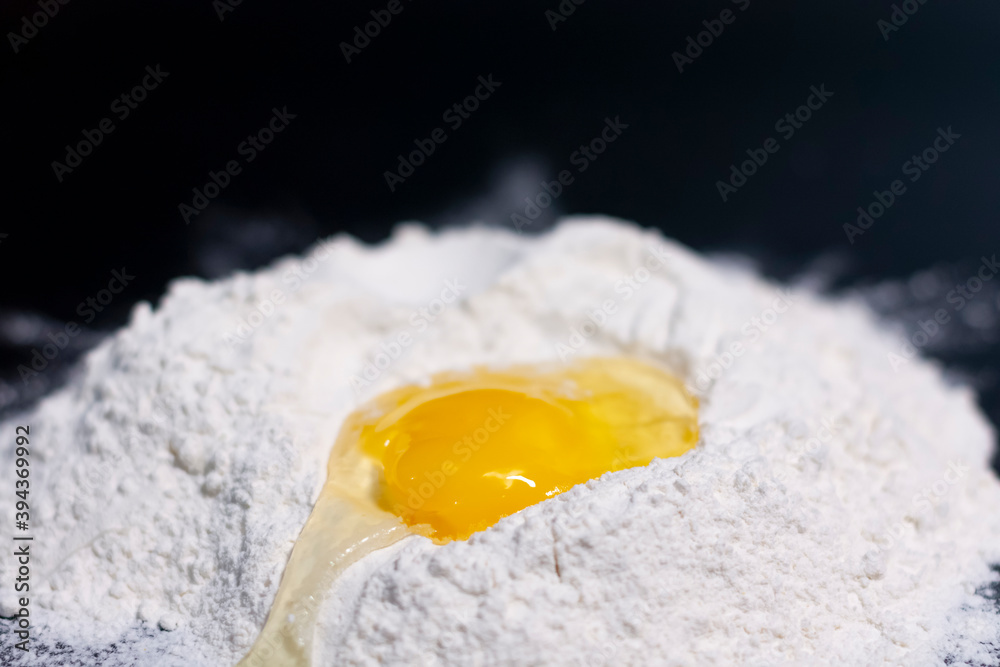 Broken chicken egg on a stack of white flour. Broken chicken egg on a stack of white flour.