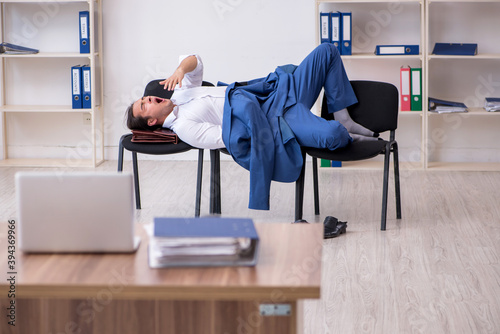 Young male employee sleeping in the office on chairs © Elnur