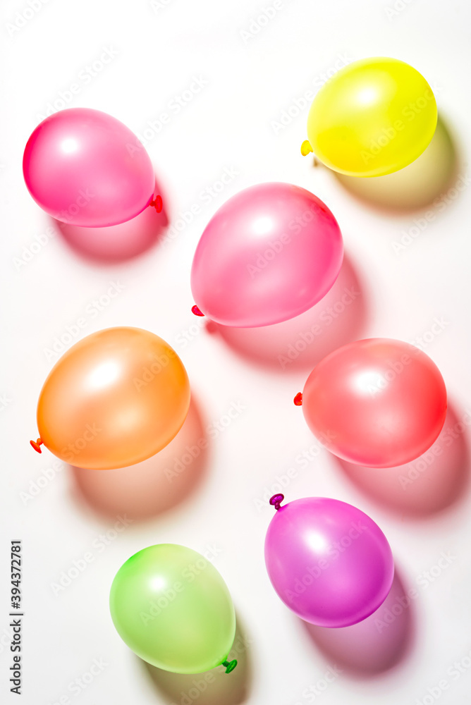 Multicolored balloons on a white background top view. Festive background with balloons. Multicolored balloons on a white background top view. Festive background with balloons.
