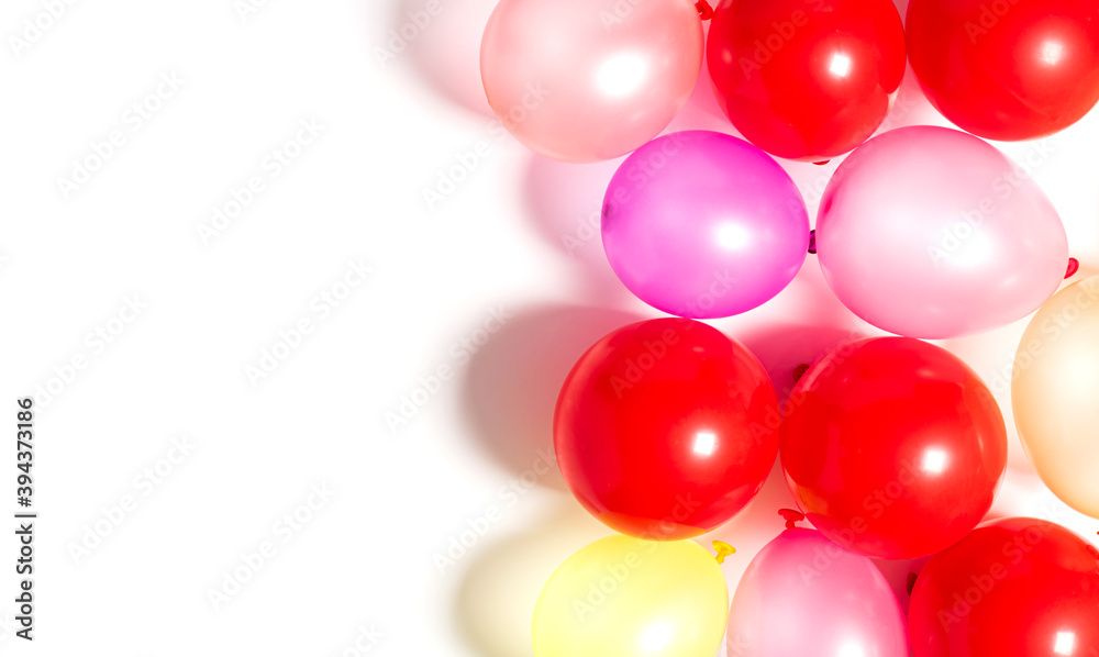 Multicolored balloons on a white background top view. Festive background with balloons.