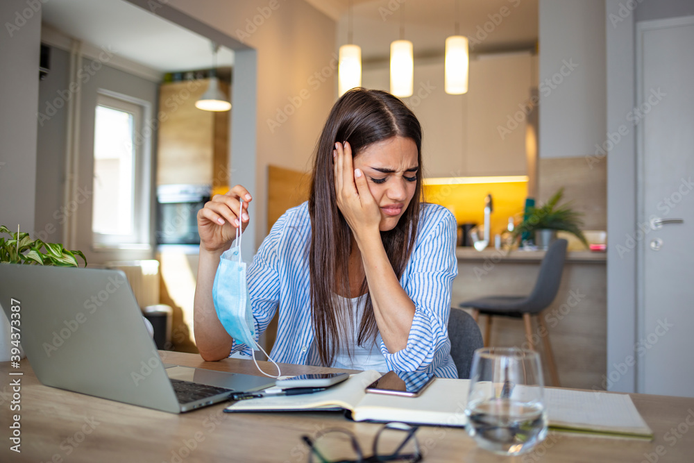 Woman Removing mask from face.  Woman with a protective face mask having breathing troubles. Risk coronavirus 2019-ncov contamination at workplace concept