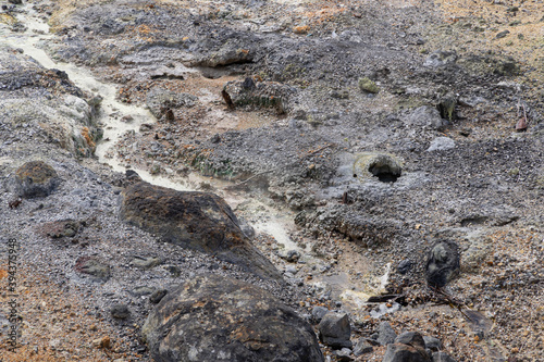 Stream of warm mud with traces of sulfur in the "Hell Valley", hot spring resort of Noboribetsu, Japan