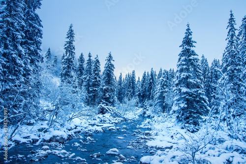 Winter mountain landscape with river. Beautiful snowy nature at Christmas time.