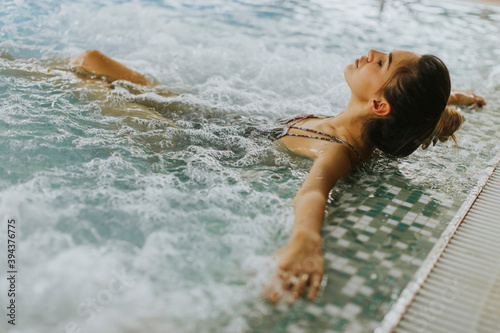 Foto Young woman relaxing in the whirlpool bathtub at the poolside