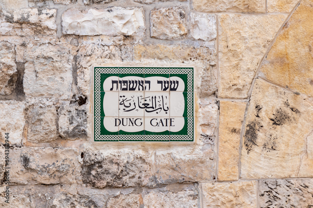 Fototapeta premium A sign in Hebrew, Arabic and English with the inscription - Dung Gate on the wall near the Dung Gate in the Old city of Jerusalem in Israel