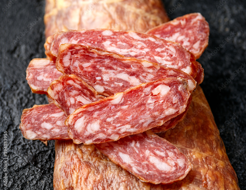 Dry cured pork meat salami slices in natural skin casing Dry cured pork meat salami slices in natural skin casing