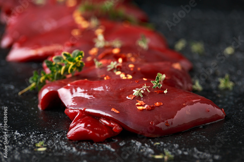 pigeon breast fillets ready to cook with seasoning mix on wooden board