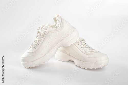 White sneakers on white background. Pair of trendy women's sneakers on white. sports shoes for cold weather