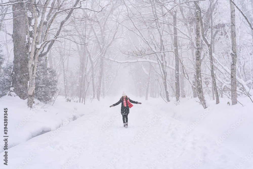 Young woman traveler enjoying with snowfall in winter
