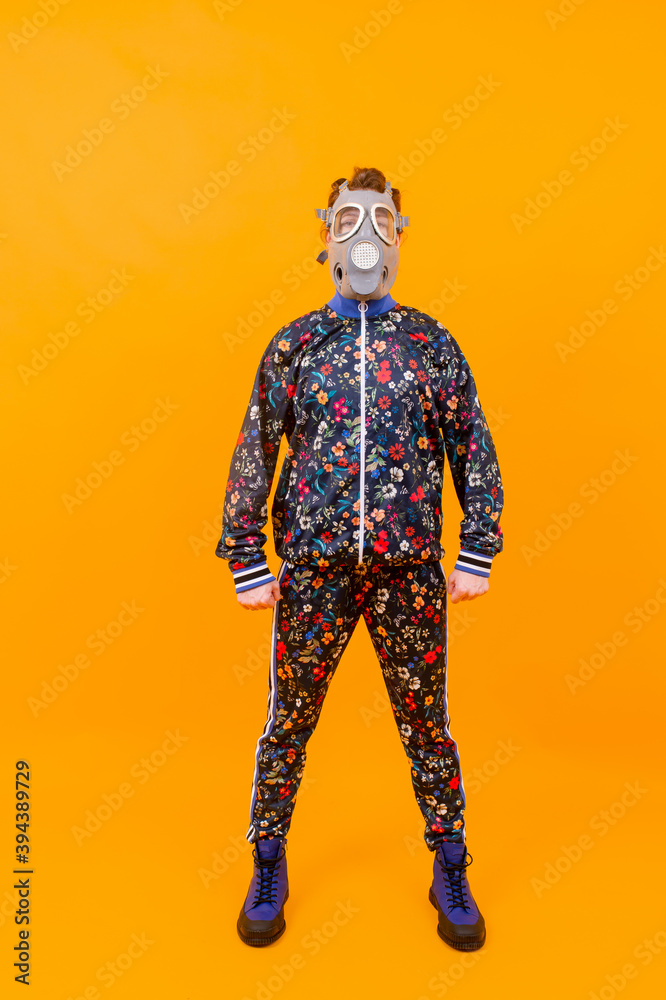Stylish strange woman in respirator posing over orange background Stylish strange woman in respirator posing over orange background